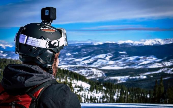 Muž v helmě s akční kamerou při pohledu na Snow Mountain